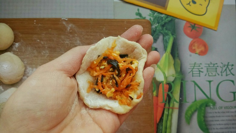 鸡仔包,把剂子用手捏成饼状(切记不要用擀面杖,擀出来的皮不利于包子的第二次涨发),在包子皮中加入馅料(馅料不要装太多,不然容易出现皮薄的地方发不起来)