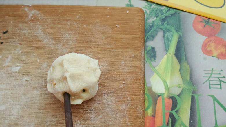 鸡仔包,为了让小鸡有神韵,我们还需要给小鸡添上眼睛,用什么来做眼睛呢?答案就是黑芝麻。
接下来又要用到小窍门了,我们把筷子尖沾湿,然后用湿筷子粘上黑芝麻粒,再用筷子戳一下小鸡的脸,黑漆漆的眼睛就这样诞生了