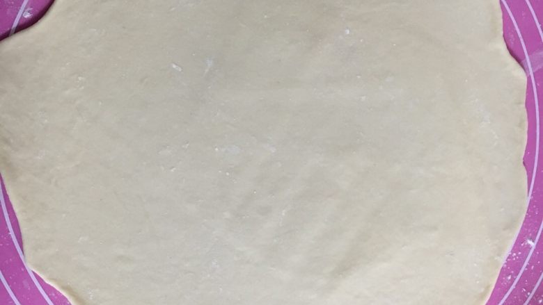 花朵中种面包,把大面团擀成一个大大的圆形,四周擀薄一些,中间厚一些