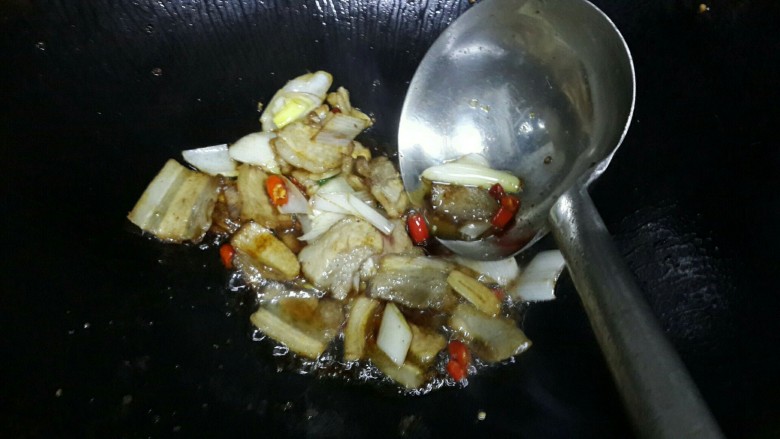 小炒肉,锅里倒油煸炒肉片，小米辣，如图