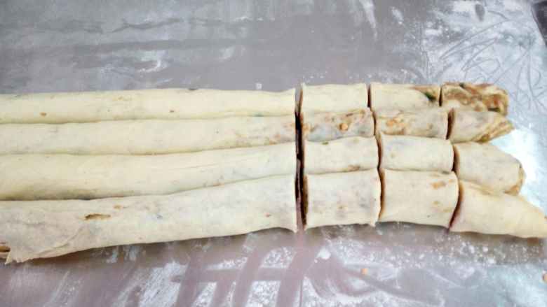 尾鸭酥,第三步擀开包馅擀成片,然后卷成条。切成段。