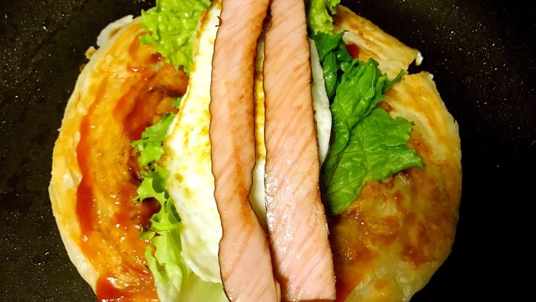 里脊蛋手抓饼,依次放入<a style='color:red;display:inline-block;' href='/shicai/ 121'>生菜</a>煎蛋和里脊肠。