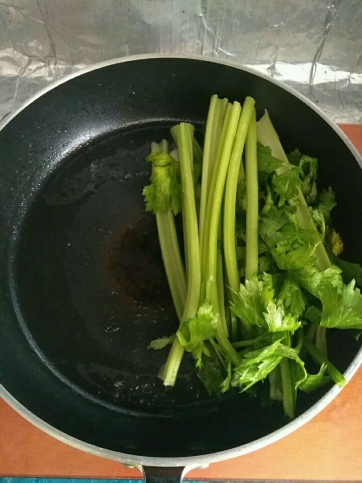 家常芹菜焖尖椒,热锅内放少量油，放入芹菜，煸炒断生。