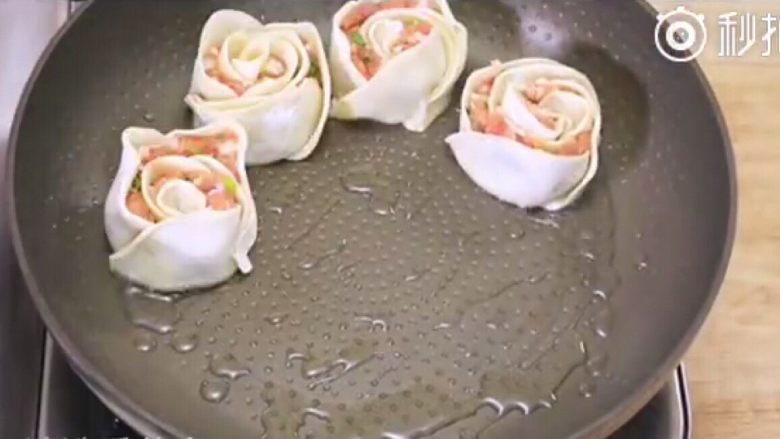 玫瑰煎饺,开大火,往锅里加入油,放入饺子,煎至底部金黄,然后加入热水,转小火