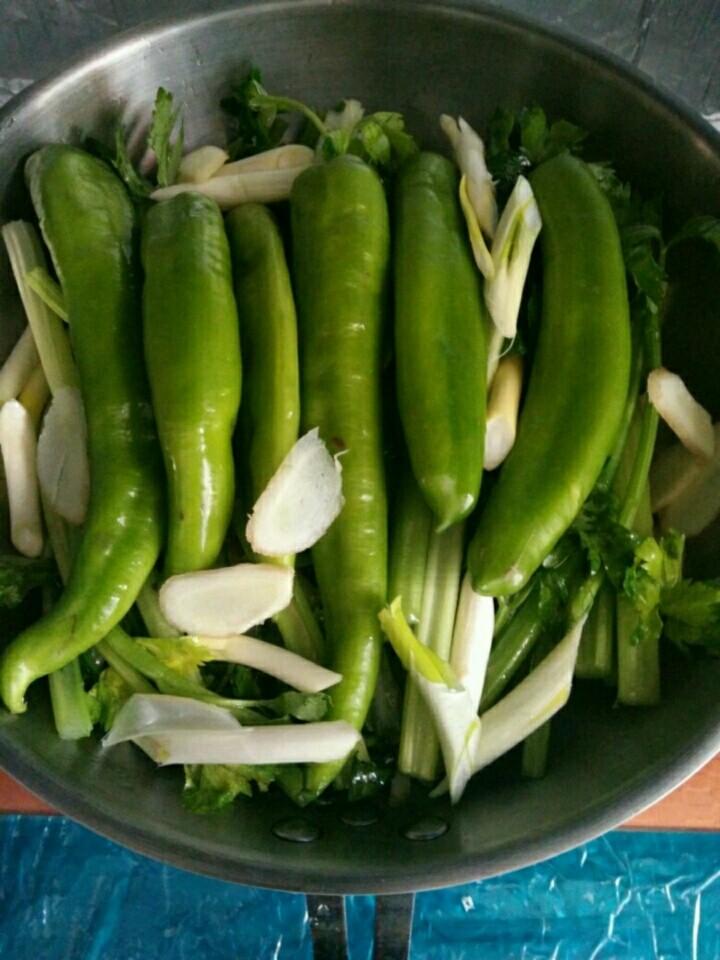 家常芹菜焖尖椒,把尖椒、葱段和姜片，放在芹菜上。