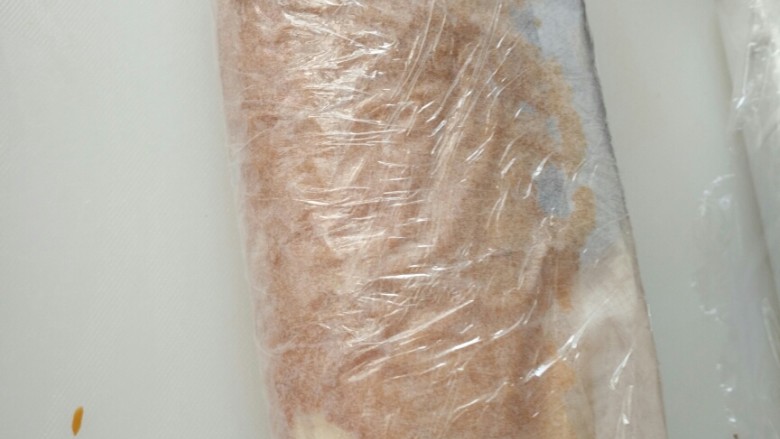 果酱奶油蛋糕卷,卷起,用油纸和保鲜膜包好,放冰箱冷藏。