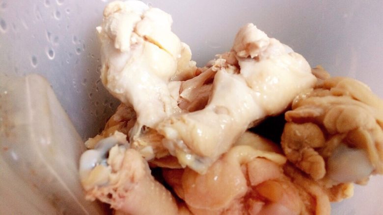 红烧鸡腿(简单易学也美味),将切好的鸡腿放入容器中待用。此时可以把蒜拿出来打扁并剥皮(打扁更好剥皮)。