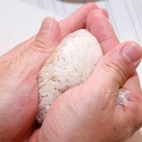 蜜汁小卷三角饭团,同时将保鲜膜四角往内包起,一手固定、一手塑形,将饭团捏紧成三角形。
也可一手固定饭团,一手用刀背辅助塑形,捏出漂亮的三角饭糰团