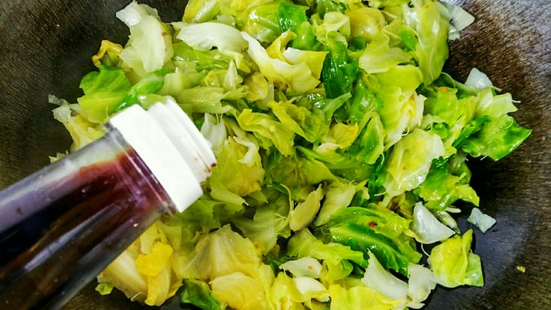手撕包菜#春意绿#,把葱香味炒出来之后,就可以关火了,此时再加入少许<a style='color:red;display:inline-block;' href='/shicai/ 692'>酱油</a>
