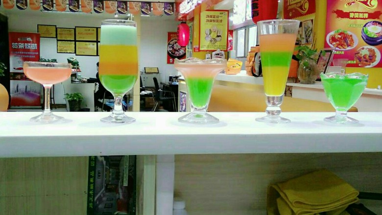 彩虹果汁,青苹果汁20毫升,蜂蜜15毫升,水60毫升倒入量杯搅拌均匀,沿着杯壁缓慢倒入果汁杯中