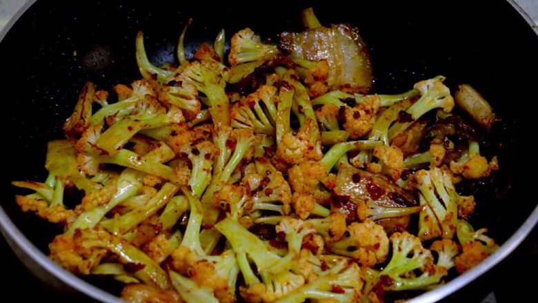 干锅菜花,炒出红油以后,翻炒菜花,炒匀,动作要快。