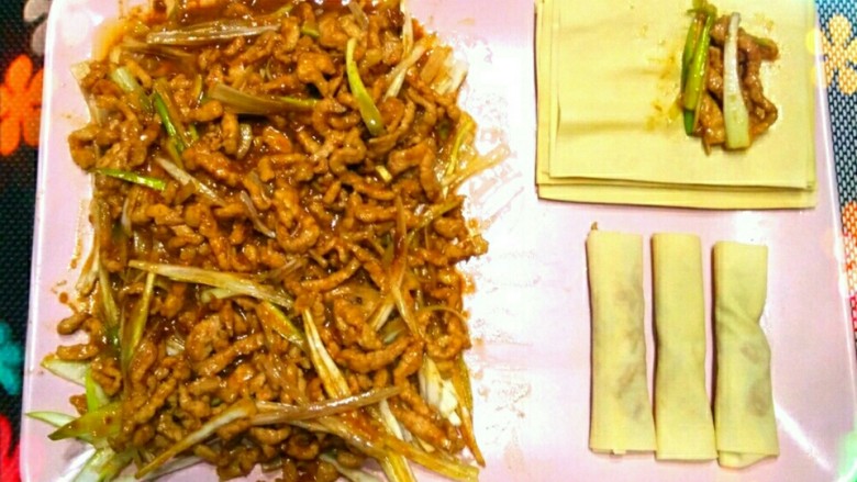家常干豆腐卷大葱,稍焖一会儿,让大葱断生,然后搅拌,最后用干豆腐卷起肉丝和葱丝。