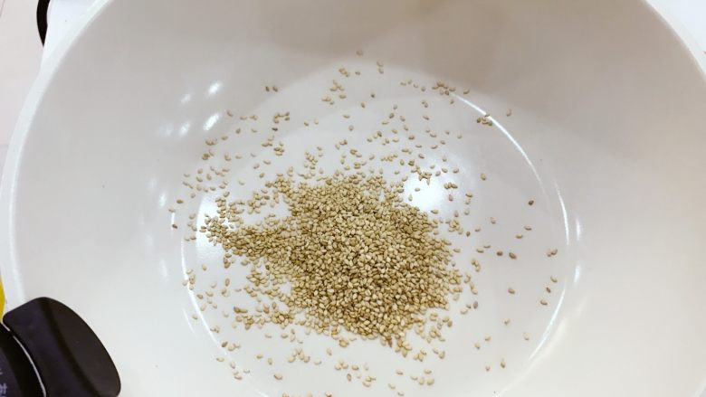 宝宝辅食:拌饭芝麻海苔-12M+,平底锅热锅,转小火,倒入<a style='color:red;display:inline-block;' href='/shicai/ 678'>白芝麻</a>,小芽用的是熟芝麻,所以简单翻炒出香味就可以啦,如果你用的是生芝麻,可以稍稍多烘一会,烘熟烘香哈,注意要时不时翻炒。
