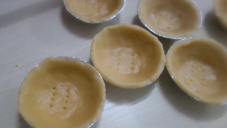 在家轻松做港式蛋挞,挞皮取出,薄薄的一层按进模具,在底部戳些小洞洞。