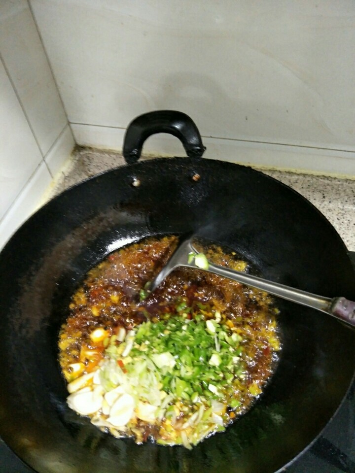 家常水煮鱼,油热了,放下大葱末,生姜末,蒜片下锅炒制