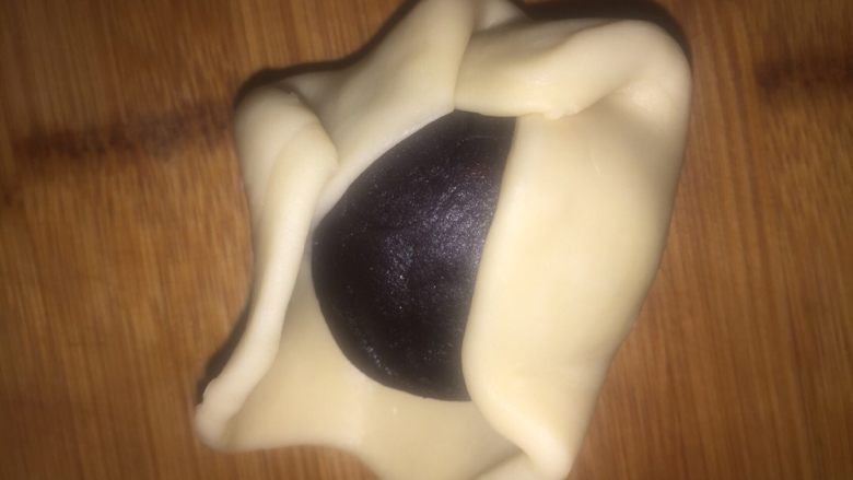 蛋黄酥,然后把豆沙球放在皮上面,用虎口收口。