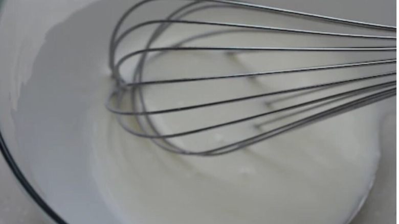 经典酸奶戚风蛋糕,酸奶倒入容器中，再倒入<a style='color:red;display:inline-block;' href='/shicai/ 846'>色拉油</a>，用手动打蛋器将两者混入均匀。