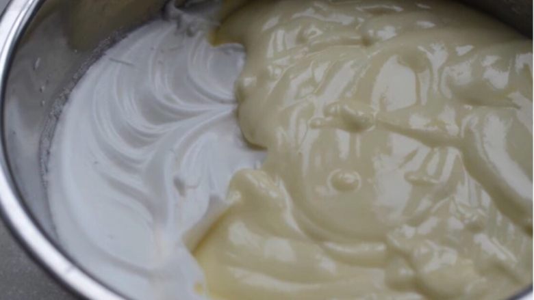 经典酸奶戚风蛋糕,取1/3的蛋白霜与蛋黄糊混合均匀，再取1/3的蛋白霜混合，将混合好的面糊倒入剩余的蛋白霜盘中，用刮刀切拌手法混合均匀。