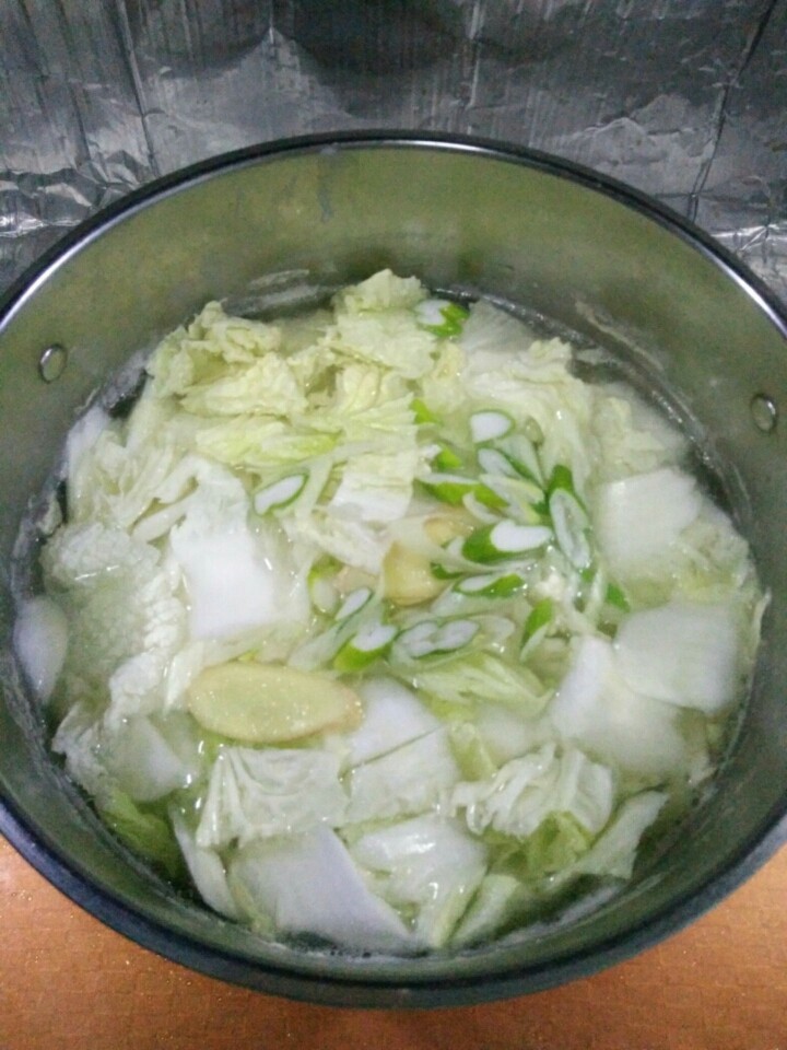 家常大白菜炖腐竹,大白菜、葱和姜放入肉汤内，加盐。