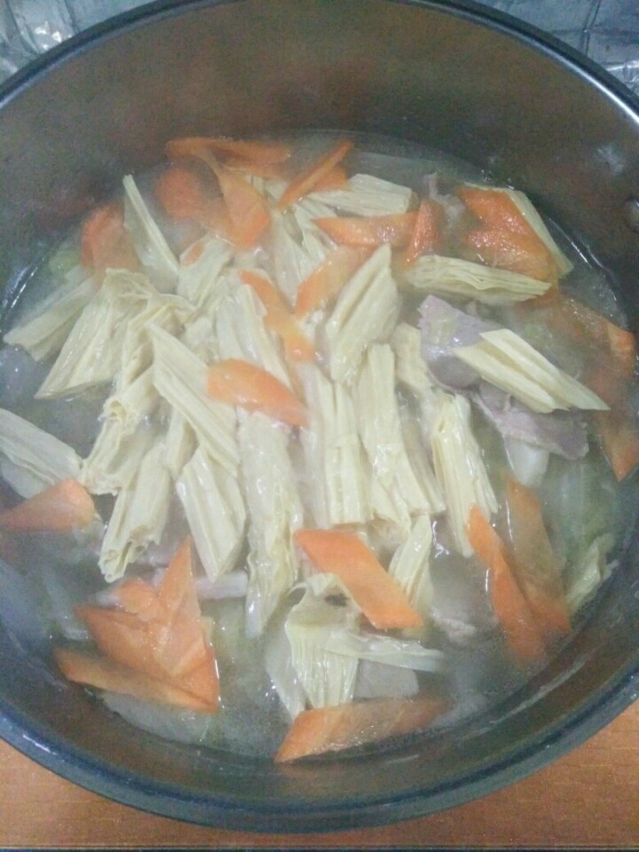 家常大白菜炖腐竹,肉片熟透后，放入腐竹和胡萝卜，煮2分钟左右。