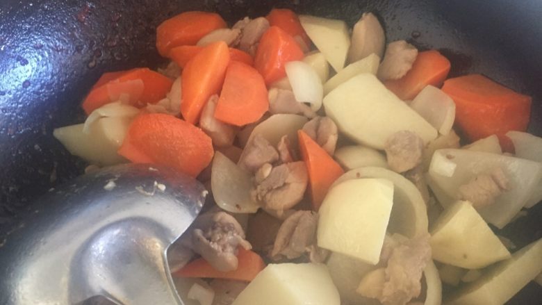 快手咖喱饭,土豆和鸡肉炒出些油时放入切好的洋葱,炒出味道时,放入胡萝卜,一起翻炒