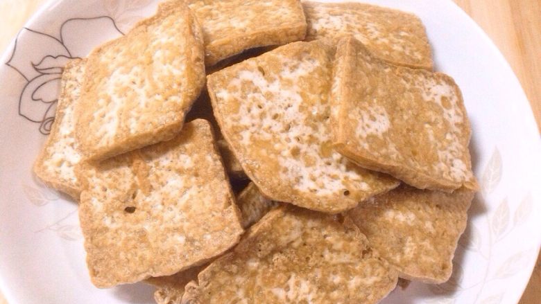 家常豆腐,待豆腐片炸至两面金黄时出锅沥油备用。