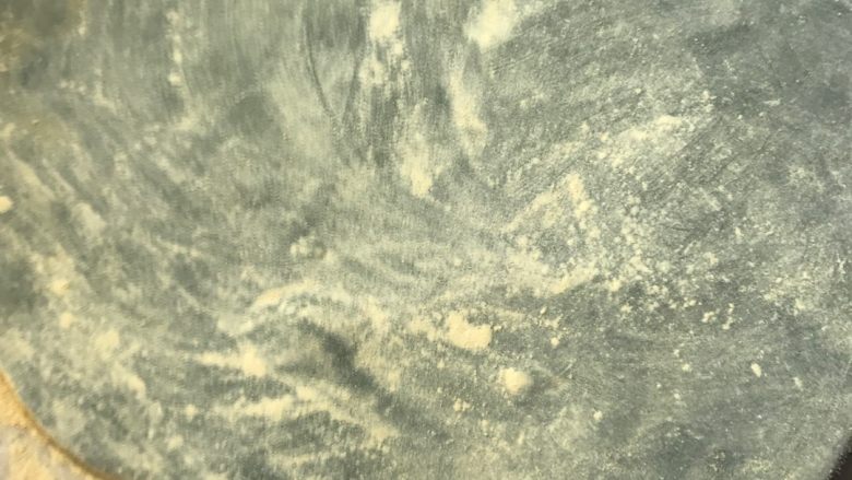 青麻糍,然后筛入松花粉,用擀面杖擀平。