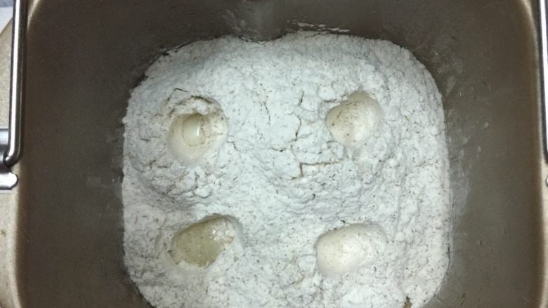 蔓越莓全麦和风面包--柏翠面包机版,在面包桶的四个角,在面粉上用手指轻轻按4个小洞
