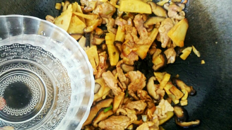 升级版山东名菜烧二冬,酱油香味四溢,迅速下入滑好的冬笋、香菇和肉片,略微翻炒后,加入一小碗热水烧制