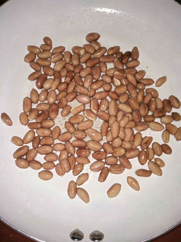 陈醋菠菜花生米,小火翻炒,花生米变色后,拿出一粒尝尝,仍有一点儿生,但香味明显,关火,利用余热再翻炒一会儿。放凉,备用。