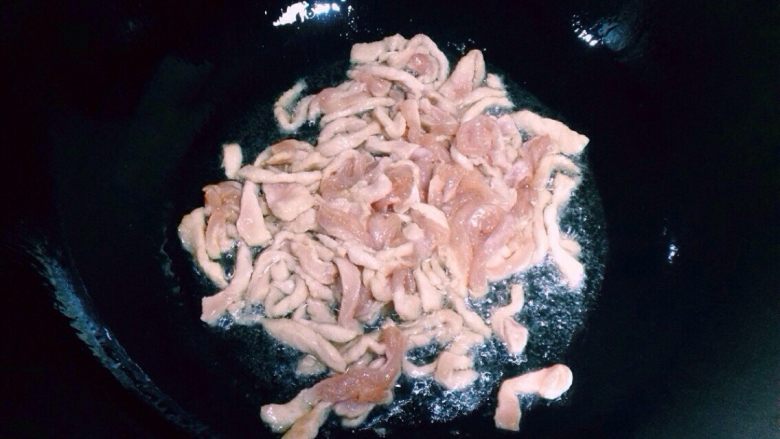 鱼香肉丝,把浆好的肉丝放入炒锅推散。