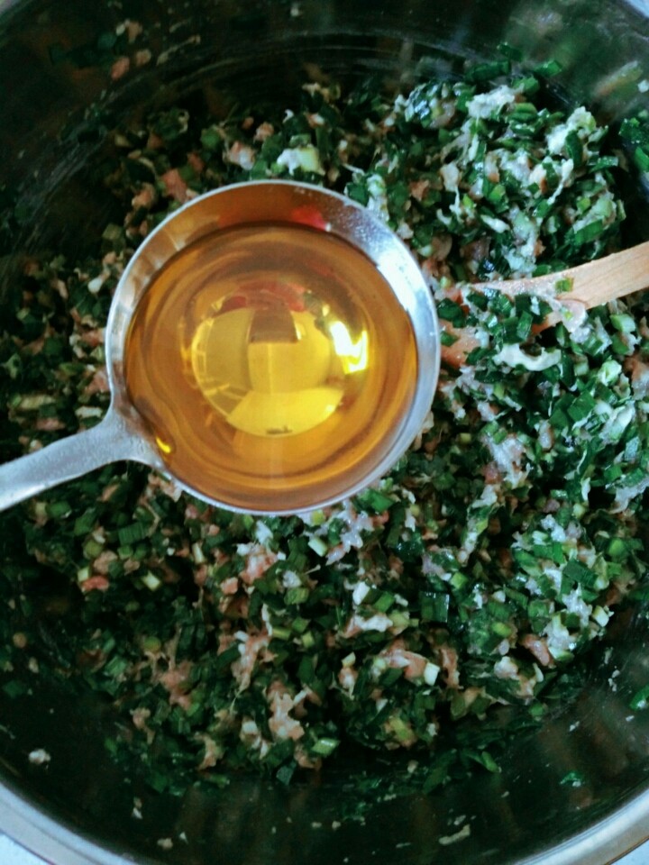 家常猪肉韭菜水饺,加入另一半熟油,锁住韭菜水分。搅拌。