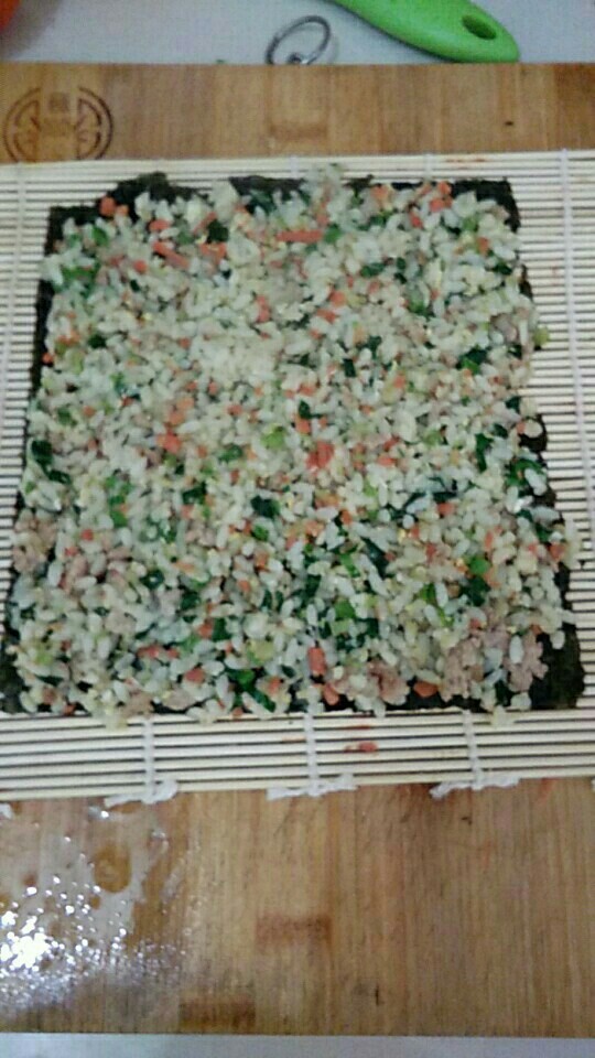 宝宝辅食青菜胡萝卜饭卷,寿司帘上放上<a style='color:red;display:inline-block;' href='/shicai/ 75430'>寿司紫菜</a>，上面铺匀炒好的青菜胡萝卜蛋炒饭，，卷起，切段，装盘，就可以了