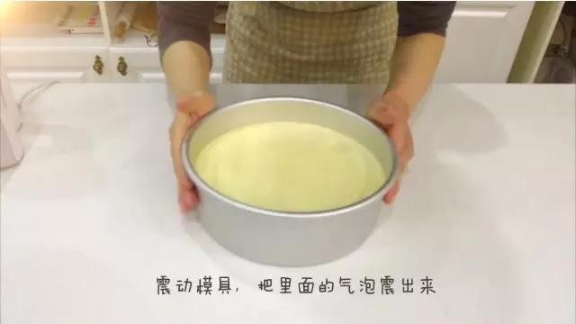 宝宝辅食:水果裸蛋糕-36M+,三、翻拌蛋糕糊及烘烤
7、捧起模具,不要太高哈,差不多10cm,震动模具,再次把里面的气泡震出来