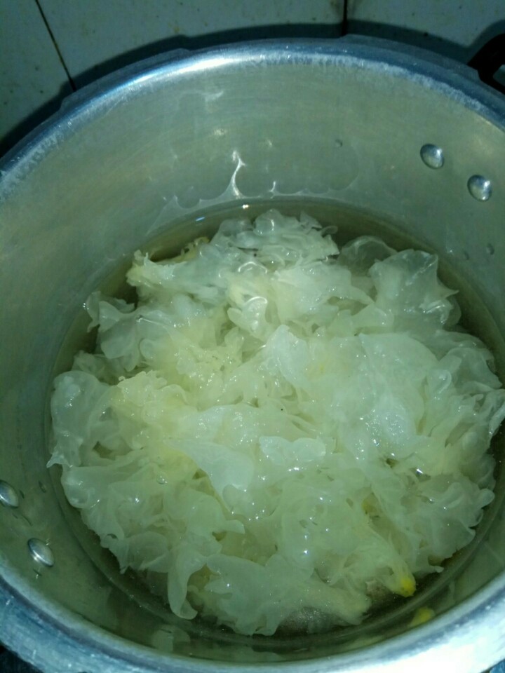 银耳菠萝枸杞糖水,把银耳上面的头切掉,然后撕小片。锅里倒入水,把备好的银耳放入锅里,中火熬煮30分钟左右