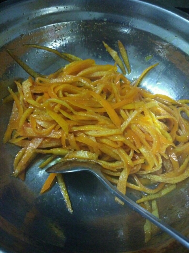 橙皮蜜饯,倒入橙皮丝,小火煮至橙皮透明,汤汁收浓,期间要不停搅拌,防止煮糊