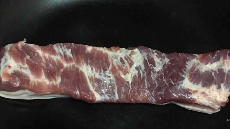 回锅肉,开中火,把肉皮贴入锅底毛烫掉