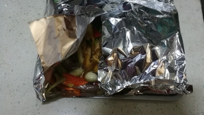 锡纸包烤鲈鱼,把锡纸从四周卷包好,要注意四角不要漏出汤汁