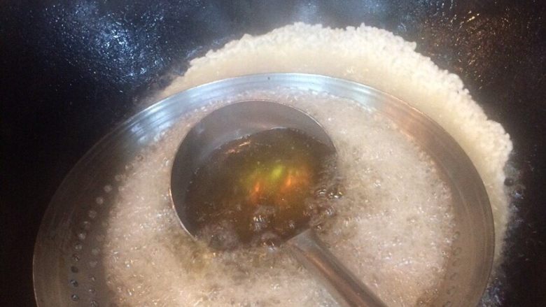 油炸锅巴,加热油 第一勺热油浇在漏勺上面流下去 不然一勺热油下去会把大米冲乱 后用漏勺把大米压压这样厚度容易均匀点 全程大火