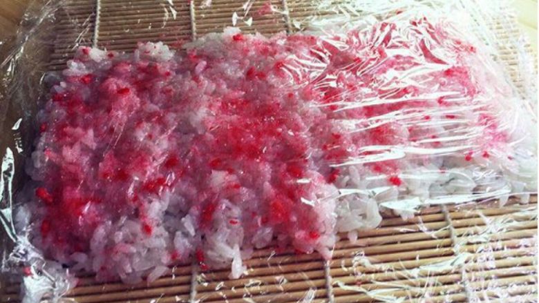 樱花寿司,再盖上一张保鲜膜,提起下面的保鲜膜翻转过来。