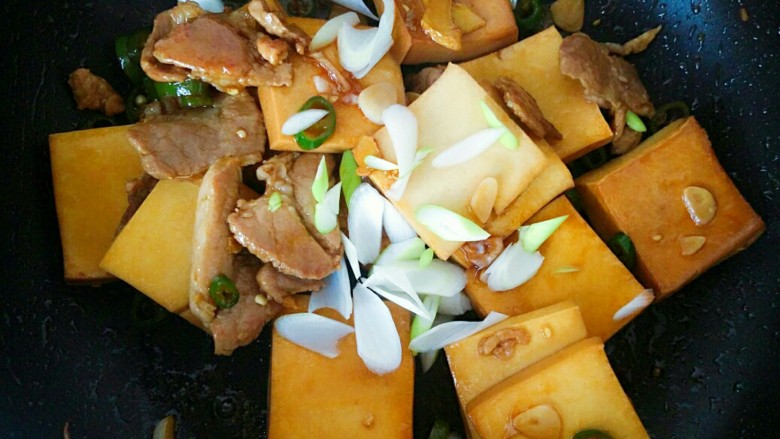小炒千叶豆腐,汤汁已经全部被豆腐吸收,这时我们撒上葱片,关火,翻炒均匀就可以出锅了