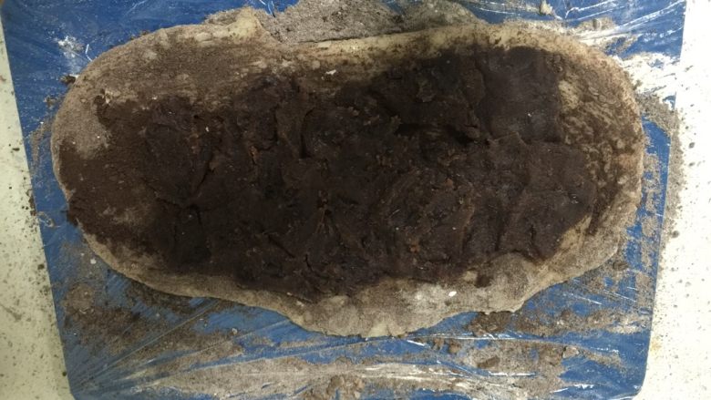 新版驴打滚,把糯米团涂抹手粉跟奥利奥粉(可以根据个人喜欢程度,也可以不加奥利奥),擀开,把豆沙铺在上面