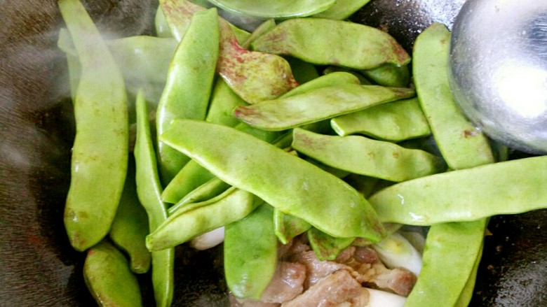 香焖油豆角,炒香葱姜之后,下入油豆角。
