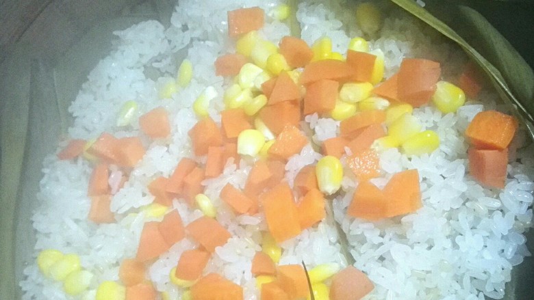 菠萝饭,锅里的米饭蒸软后加胡萝卜丁继续蒸