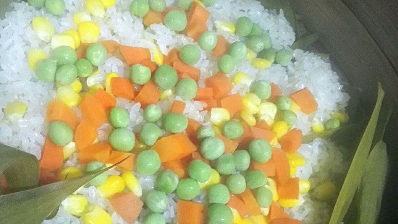 菠萝饭,这时米饭已经熟了,豌豆易熟这时候加,小火再焖会儿,豆子呈翠绿色就可以关火了