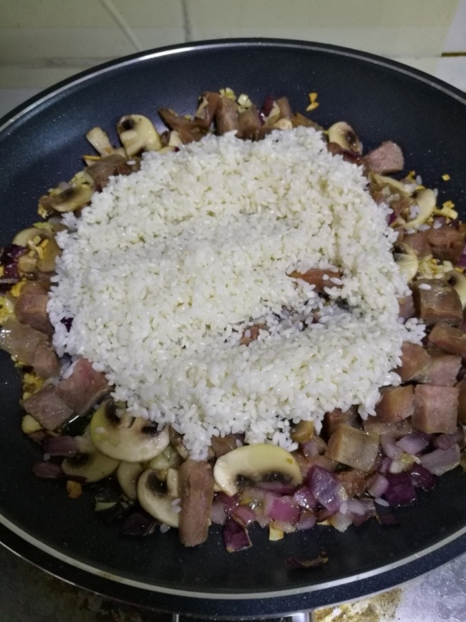 红酒香肠燉饭,炒出香味后,再加入白米翻炒。