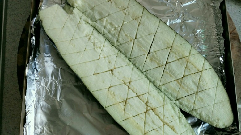 蒜蓉烤茄子,茄子洗净,用刀对切开,茄肉用刀划出菱形块