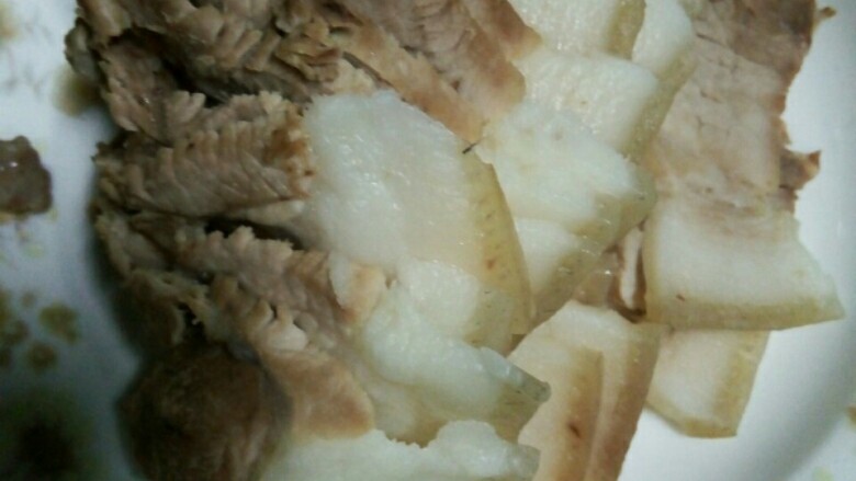 回锅肉,猪肉洗净淖去血水,加姜冷水烧开煮三十分钟,捞起切片。