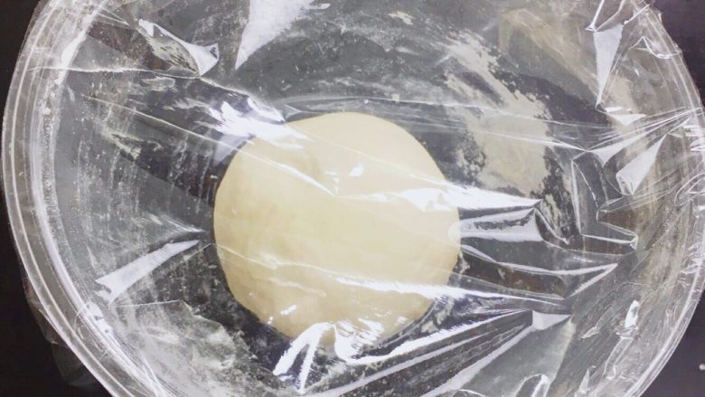 💛卡门培尔奶酪香肠面包💛,将面团团成团后,缝口朝下放入面包盆内,盖上保鲜膜。40℃发酵25-35分钟。