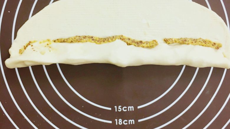 💛卡门培尔奶酪香肠面包💛,将面团紧紧地卷起来、边涂上芥末粒